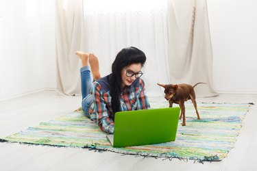 Young girl on white sofa with a laptop