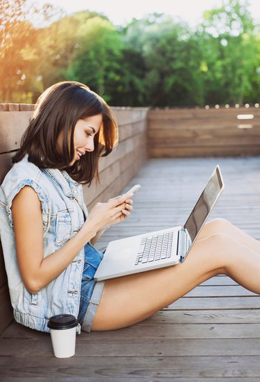 Young woman using a laptop and smart phone