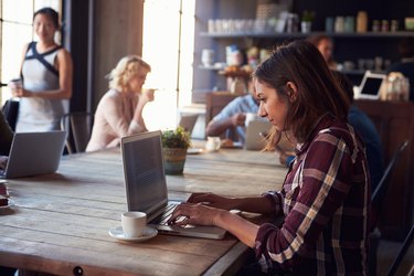 Interior Of Coffee Shop With Customers Using Digital Devices