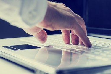 Man typing on a laptop keyboard