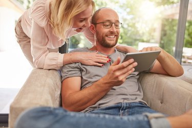 Couple using a digital tablet smiling