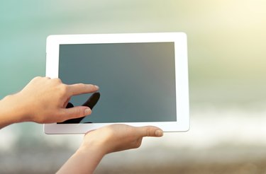 white tablet with a  blank screen in the hands