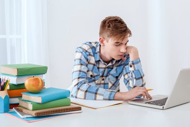 Cute young student using laptop