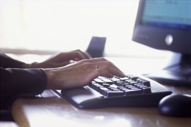 Woman's hands typing on computer keyboard