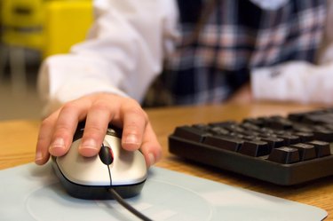 Child's hand on a computer mouse.