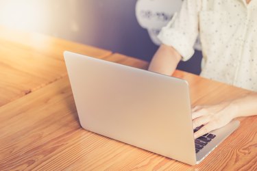 Hand woman typing key pad of laptop.