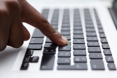 black finger typing on computer keyboard