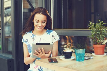 Young woman using digital tablet at cafe