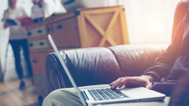 Man with laptop on leather sofa