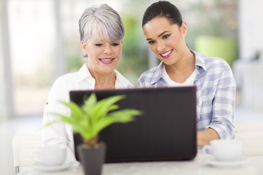 senior mother and daughter using laptop computer