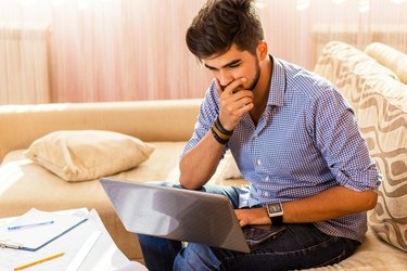 Young male student working at home.