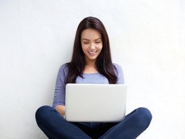 Smiling young woman using laptop