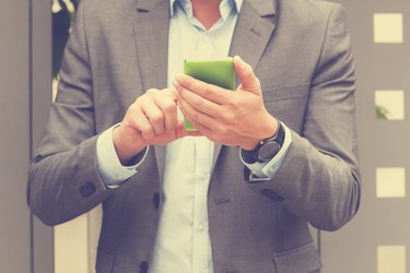 Elegant man using cellphone outdoors.