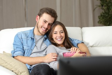 Happy couple watching movie on tv