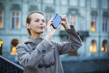 Elegant, young woman taking a photo