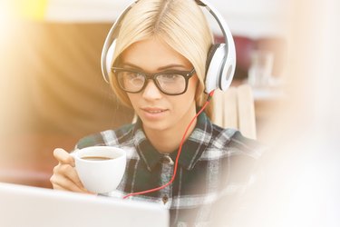 Cheerful young woman is resting with technology