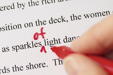 Hand with Red Pen Proofreading Text Closeup