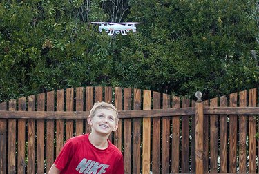 A young boy flying a drone