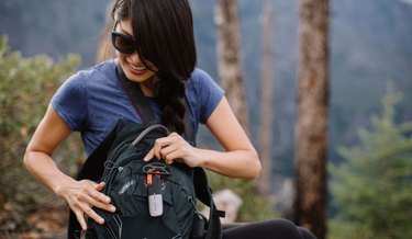 Photo of a hiker with a goTenna Mesh long-range, off-the-grid antenna attached to her backpack.