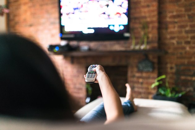 woman relaxing online on sofa reading some papers
