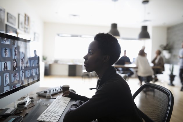 Female photo editor reviewing digital photo proofs on computer in office
