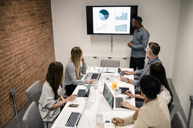 Young man has presentation with graph on lcd screen