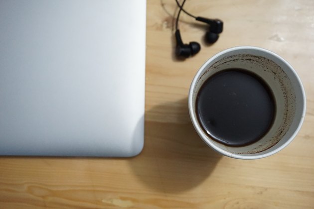 Cup of black coffee and MacBook on the table