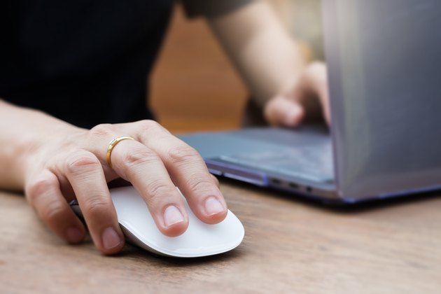 Midsection Of Woman Using Laptop On Table