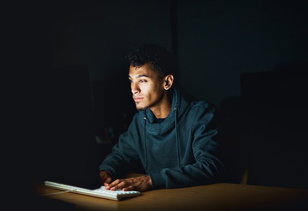 Young man working on computer late at night