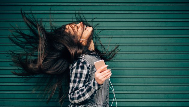 Teenage girl listening to the music and shaking head