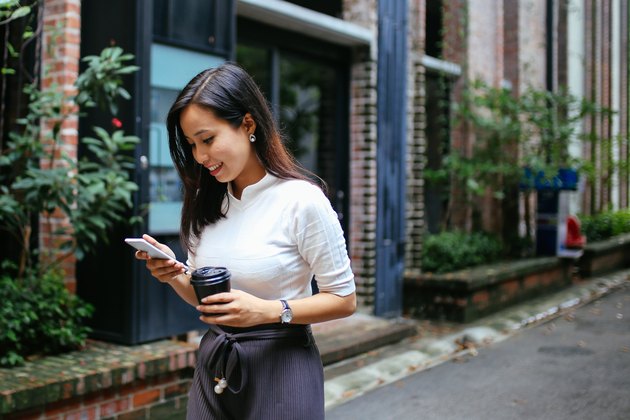 Young woman having a coffee on the go in Kuala Lumpur, Malaysia