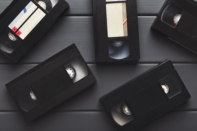 Video cassettes on gray wooden surface . Back to the past