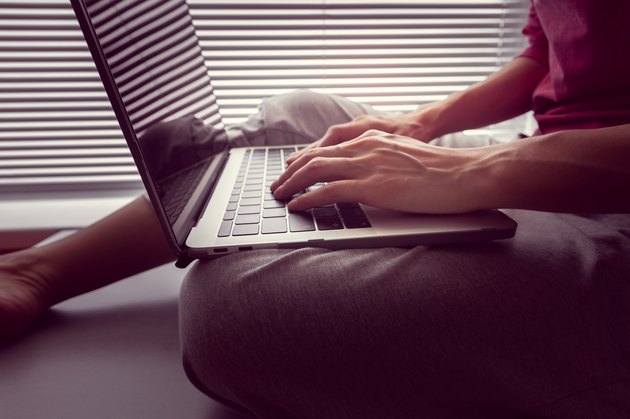 girl holds a MacBook Pro Retina on her lap and something prints