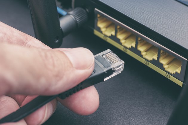 Person plugging in cable to wireless router