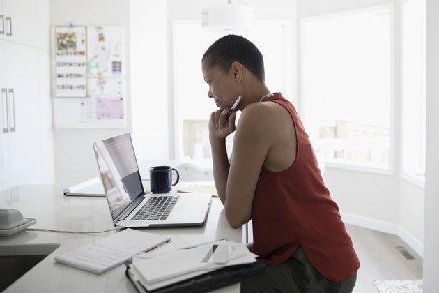Mature woman using laptop in kitchen
