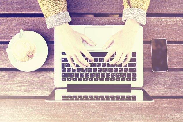 Girl with laptop, cell phone and cup of coffee