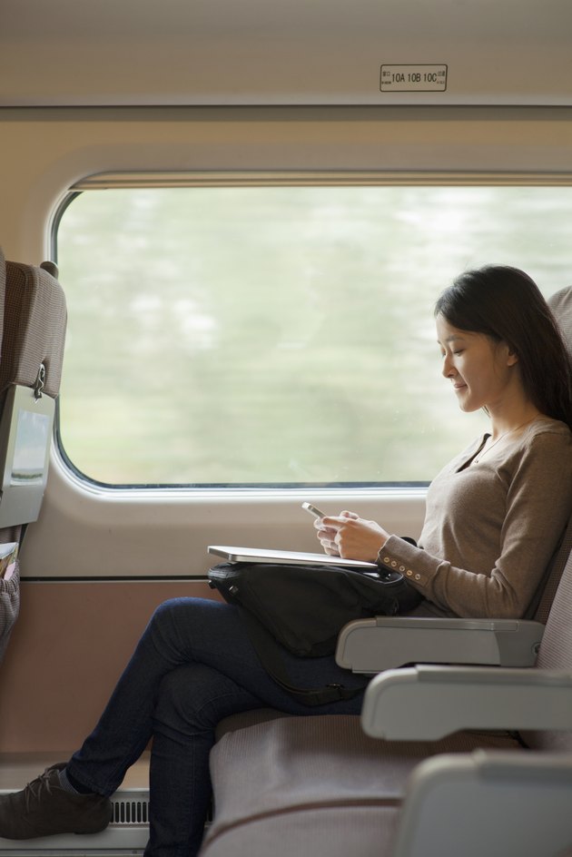 Young woman sitting on a train using her phone