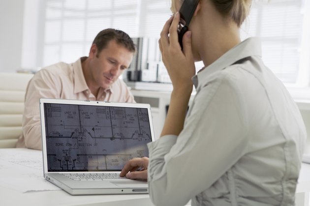 Architects with laptop with woman using cell phone