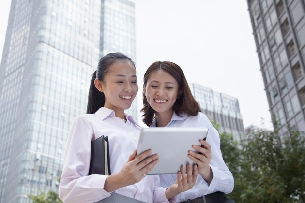 Two young businesswomen discussing outdoors