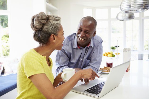 Mature African American Couple Using Laptop At Breakfast
