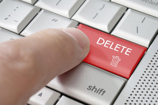 Business concept male finger pointing delete key