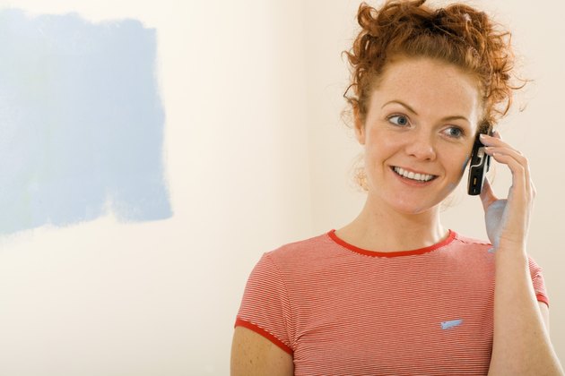 Smiling woman on cell phone in new home