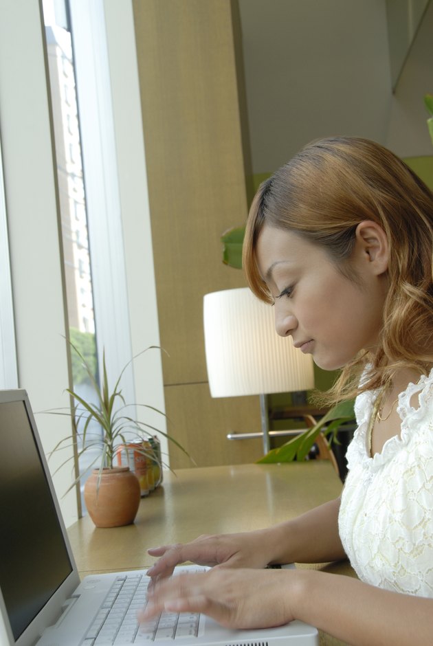 Young woman using laptop in cafe, blurred motion