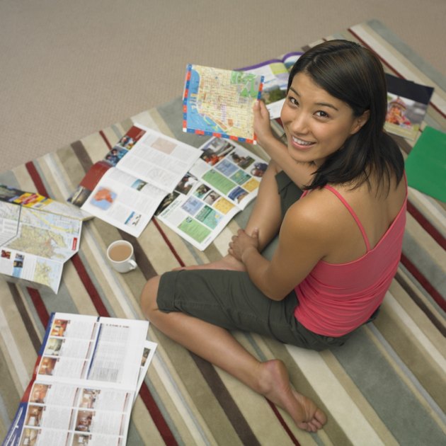 High angle view of Asian woman looking at travel brochures
