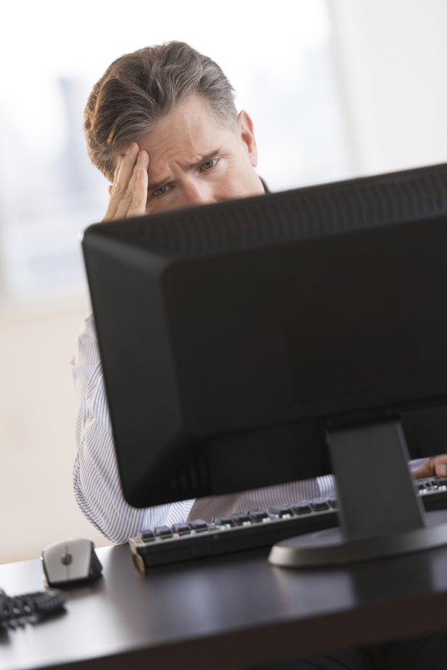 Tensed Businessman Looking At Computer Monitor
