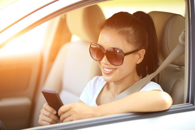 happy woman driver use her cell phone in car
