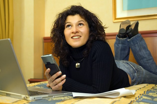 Woman using pda and laptop