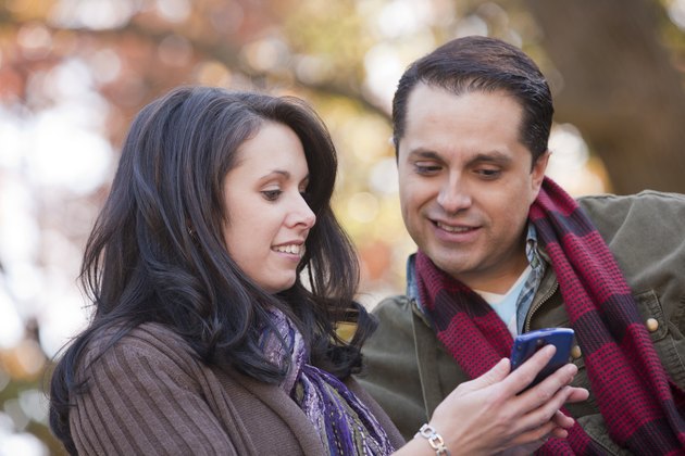 Couple text messaging on a mobile phone