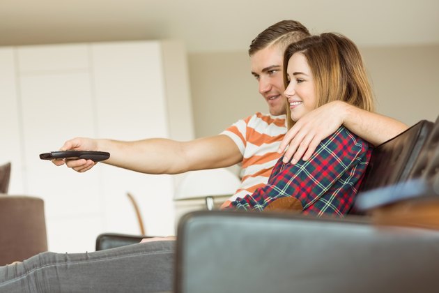 Cute couple relaxing on couch watching tv