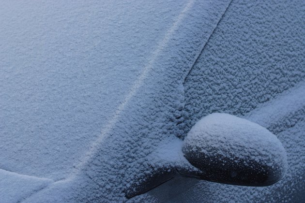 Frozen car covered in snow